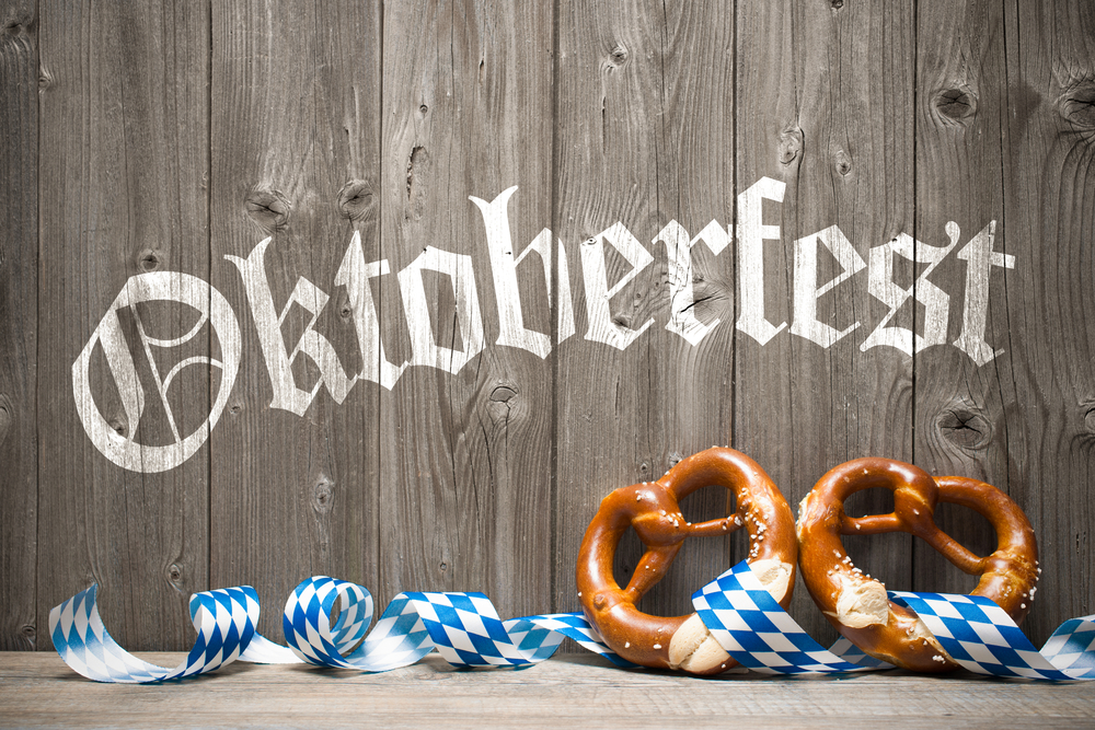 Bavarian pretzels with ribbon on wooden board. Background for Oktoberfest